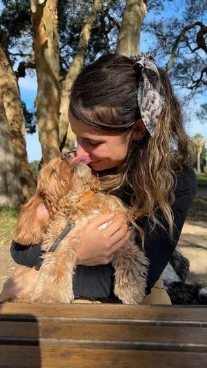 Mireya cuddling a golden pup